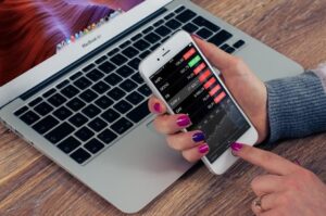 A girl is checking stocks portfolio on her phone screen