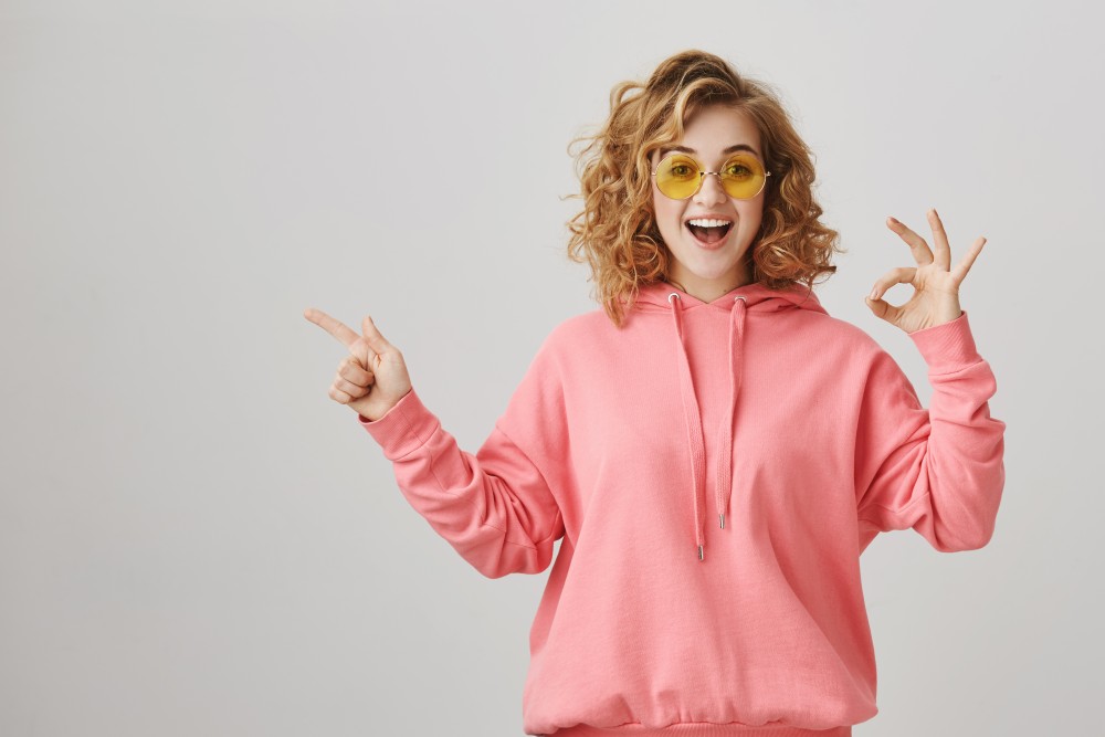 surprised-happy-girl-pointing-left-recommend-product-advertisement-make-okay-gesture