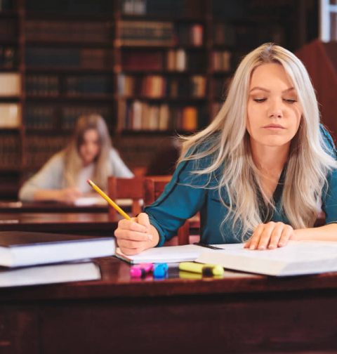 woman-working-desk-taking-notes