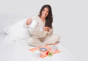 cheerful-middle-aged-woman-having-breakfast-bed_181624-52088